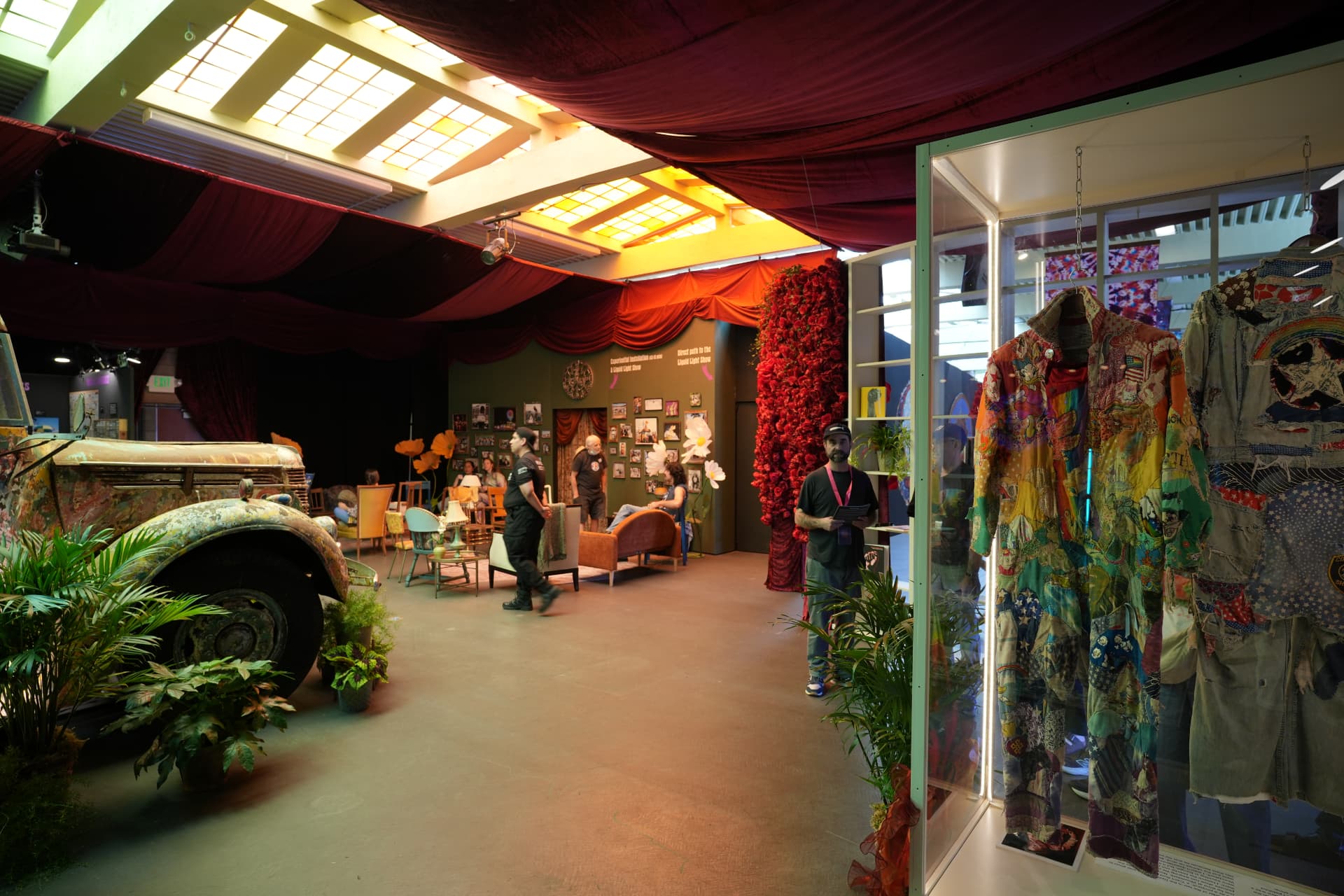 Red velvet lounge under amber skylights with vintage furniture