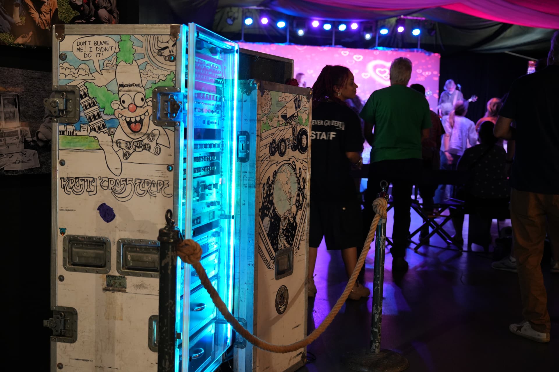 Hand-illustrated road case lit in neon beside the performance stage