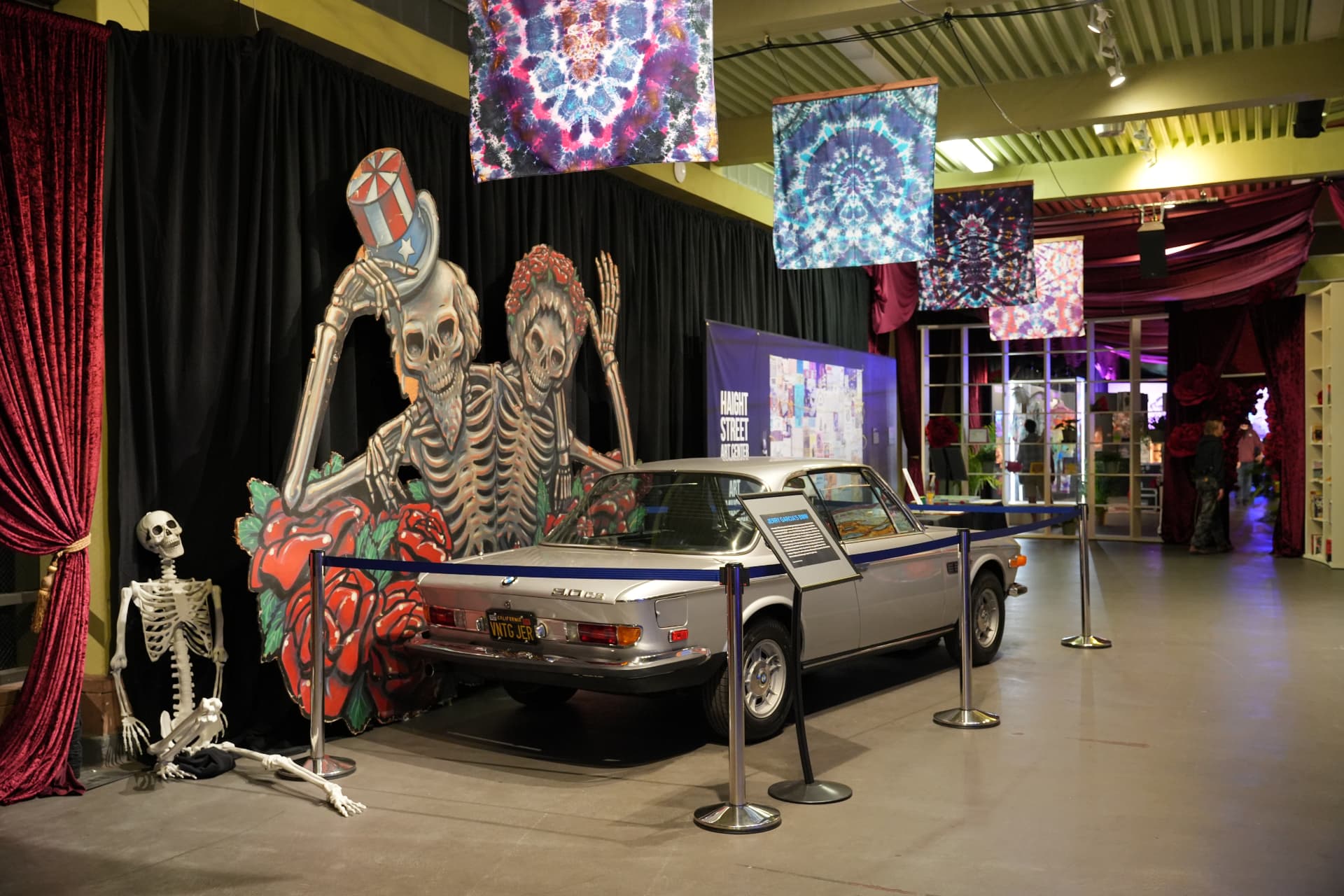 Skeleton and roses cutouts behind a vintage BMW roadster